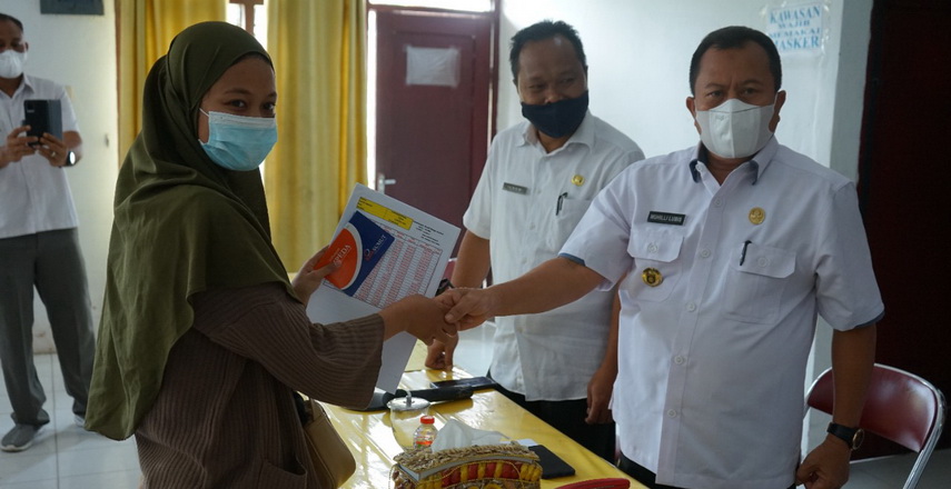 Bupati Asahan melalui Kadis Kopdag Drs Ilham menyerahkan buku tabungan dana pinjaman bergulir kepada 103 pelaku usaha mikro diaula Diskopdag Asahan, Rabu (16/3/2022).