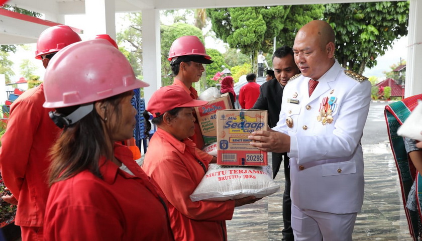 Bupati Taput Dr Nikson Nababan MSi menyerahkan secara simbolis bantuan bagi 18 keluarga korban kebakaran Pasar Sarulla Kecamatan Pahae Jae.