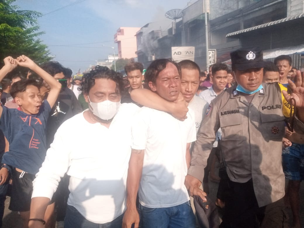 Erwin Tampubolon diteriaki warga sebagai copet dan diamankan pihak kepolisian terkait dugaan menjarah barang-barang dari ruko yang mengalami kebakaran di Jalan Patuan Anggi Parluasan, Kamis (30/3/2023), sekira pukul 16.15 WIB.