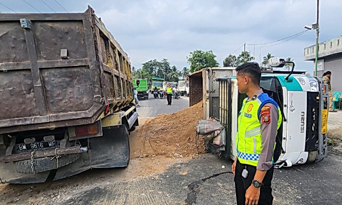 Polisi menilang truk yang mengangkut tanah karena membuat kemacetan arus mudik usai mengalami kecelakaan tunggal terbalik di daerah Durin Simbelang, Pancurbatu, Senin (8/4/2024)