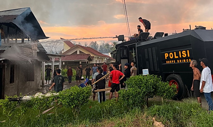 Rumah warga telah terbakar, personil Kompi 4 Batalyon C Sat Brimob Kepulauan Nias Polda Sumut, gerak cepat turun di TKP memadamkan api.
